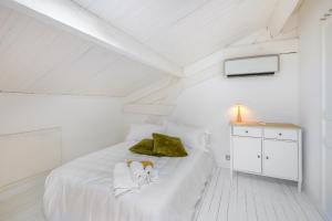 ein weißes Schlafzimmer mit einem Bett mit einem Hund drauf in der Unterkunft Appartement de luxe bluesky in Beausoleil