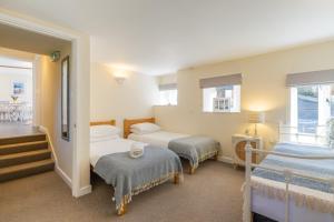 a bedroom with two beds and a balcony at Putts Cottage in Braunton