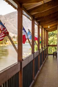 een veranda met een Amerikaanse vlag en uitzicht op een rivier bij Hospedaje Chaska Pisac in Pisac