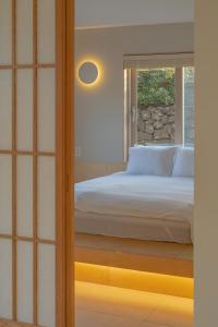 a bedroom with a bed and a window at Aewol Gilro in Jeju