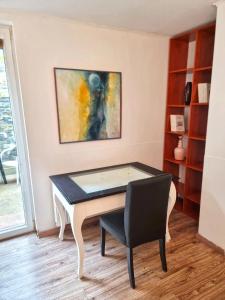una mesa y una silla en una habitación en Cosy Studio with Garden Near the Prague Airport 