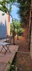 ławka siedząca na chodniku obok drzew w obiekcie Cosy Studio with Garden Near the Prague Airport 