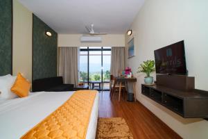 a hotel room with a bed and a television at Gaurav Lords Resort in Srīvardhan