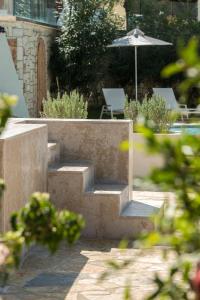 un escalier avec un parasol dans la cour dans l'établissement Erietta Aparthotel, à Tsilivi