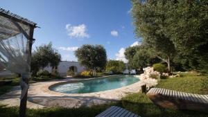a swimming pool in the yard of a house at Dimora Trullivo, Charming House in Castellana Grotte