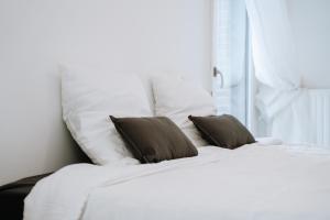 a white bed with two pillows and a window at Appartement Paris La Défense U Arena in Nanterre