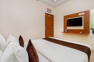 a bedroom with a bed and a tv on the wall at Hotel Raheja Residency in Mumbai