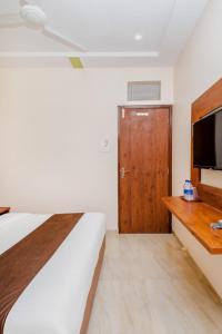 um quarto com uma cama e uma televisão de ecrã plano em Hotel Raheja Residency em Mumbai