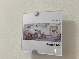 un cartel en una pared con una motocicleta. en Route 66 Appartement, en Bad Salzuflen