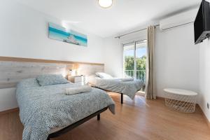 Un dormitorio con dos camas y una gran ventana. en Apartment Mijas Sun and Beach, en Sitio de Calahonda