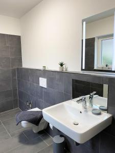 La salle de bains est pourvue d'un lavabo et d'un miroir. dans l'établissement Route 66 Appartement, à Bad Salzuflen