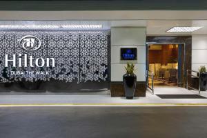 un front de magasin avec un panneau indiquant l'hôtel dans l'établissement Hilton Dubai The Walk, à Dubaï