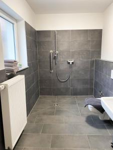 La salle de bains est pourvue d'une douche et d'un lavabo. dans l'établissement Route 66 Appartement, à Bad Salzuflen