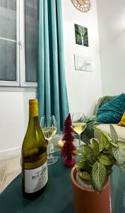 butelkę wina i dwa kieliszki na stole w obiekcie AngeVert HolidayHouse w Nicei