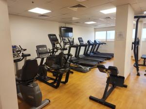 un gimnasio con filas de cintas de correr y máquinas elípticas en Elite 6 Sports Residence by Golden Casa, en Dubái