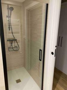 puerta de ducha de cristal con silla en una habitación en Apartamento Elkano 1, en Hernani