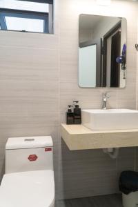 La salle de bains est pourvue de toilettes blanches et d'un lavabo. dans l'établissement T Home Balcony, à Hanoï