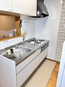 uma cozinha com um lavatório e um fogão em HimawariRyokanひまわり旅館 em Okayama
