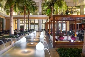 a lobby of a hotel with palm trees at Hyatt Regency Oryx Doha in Doha