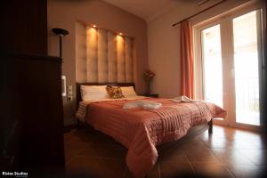 a bedroom with a bed with a large window at Elena Rista Studios in Parga
