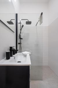 ein weißes Bad mit einem Waschbecken und einer Dusche in der Unterkunft Stellar Dwell Apartment in Budapest