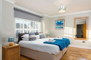 a bedroom with a bed with a blue blanket on it at Kilrymont View in St. Andrews