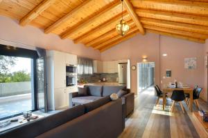 ein Wohnzimmer mit großer Couch und Küche in der Unterkunft Corfu Travel Stories Villa, Private Pool - Stunning Sea Views - Accessible - 4 Bedrooms in Áno Pavliána