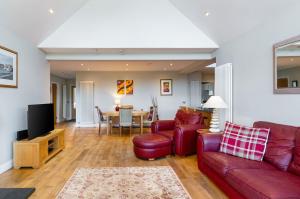 a living room with a red couch and a table at Kilrymont View in St. Andrews