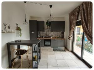 a kitchen with black cabinets and a table in a room at Domeanto home in Catania