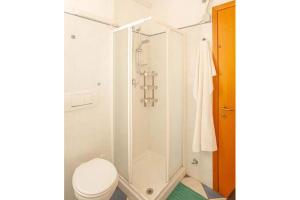 Un baño blanco con ducha y WC. en Giglio Viola, en Campese