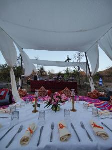 a white table with silverware and flowers on it at The Jungle Lust in Kumbhalgarh