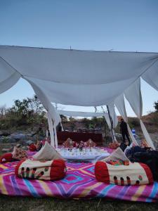 a group of beds on a blanket under a tent at The Jungle Lust in Kumbhalgarh