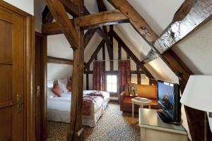 a bedroom with a bed in a room with wooden beams at Auberge Saint Pierre in Le Mont Saint Michel