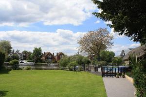 a park next to a river with houses at Old Wharf Cottage - Riverside Living with Pool in Wraysbury