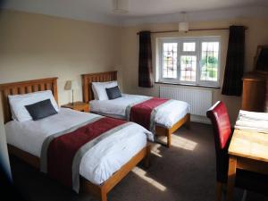 a hotel room with two beds and a window at Old Wharf Cottage - Riverside Living with Pool in Wraysbury
