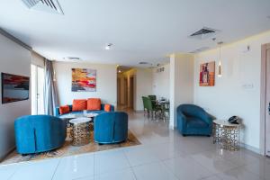 sala de estar con sillas azules y sofá en Wahaj Boulevard Hotel Apartmentوهج بوليفارد للشقق الفندقية, en Kuwait