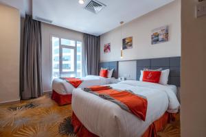 um quarto de hotel com duas camas e uma janela em Wahaj Boulevard Hotel Apartmentوهج بوليفارد للشقق الفندقية em Kuwait