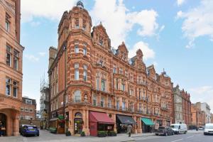 un grand bâtiment en briques rouges dans une rue de la ville dans l'établissement Best Mayfair Location with 2 Super King Beds, à Londres