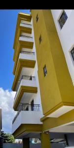 a yellow and white building with balconies on it at The Presidential Suite in Ruiru
