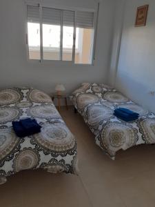 Duas camas num quarto com uma janela em Ground floor Jardin D'alba Villamartin em Cabo Roig