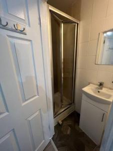 La salle de bains est pourvue d'une douche, de toilettes et d'un lavabo. dans l'établissement Beatle Luxy Apartment, à Feltham