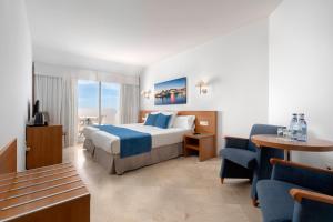 een hotelkamer met een bed en een stoel bij Aluasun Lago Rojo - Adults recommended in Torremolinos