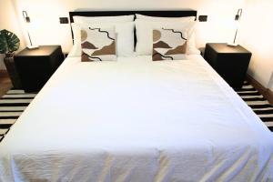 1 dormitorio con 1 cama blanca y 2 mesitas de noche en Ecosuite your design Escape en Roma