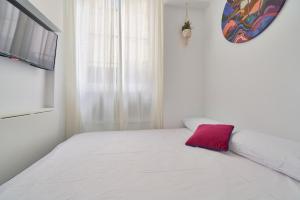 マラガにあるSuite Málaga Centerのベッドルーム(ピンクの枕と白いベッド付)