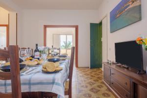 uma sala de jantar com uma mesa e uma televisão de ecrã plano em Maestrale Sea View Living Quarters em Porto Cesareo