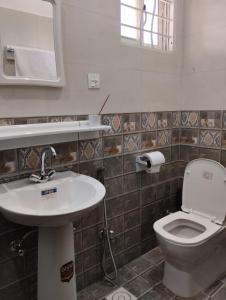 a bathroom with a sink and a toilet at ITL GUESTHOUSE in Rawalpindi