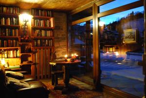 ein Wohnzimmer mit einem großen Fenster und einem Tisch mit Kerzen in der Unterkunft Hotel Bellevue in Champoluc