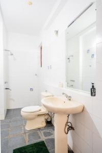 a white bathroom with a toilet and a sink at The Fields Malabe in Malabe