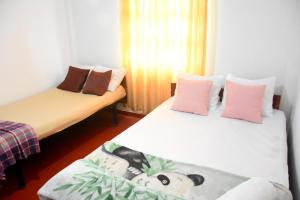 two beds in a room with pink and white at The Dew Drop Villa in Nuwara Eliya