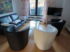 sala de estar con sofá, sillas y TV en Ferienwohnung "Am Münstertor", en Telgte